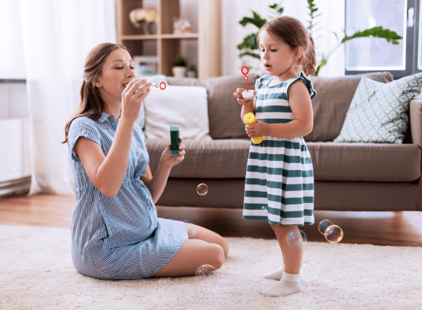 A child blowing bubblues with a parent or therapist